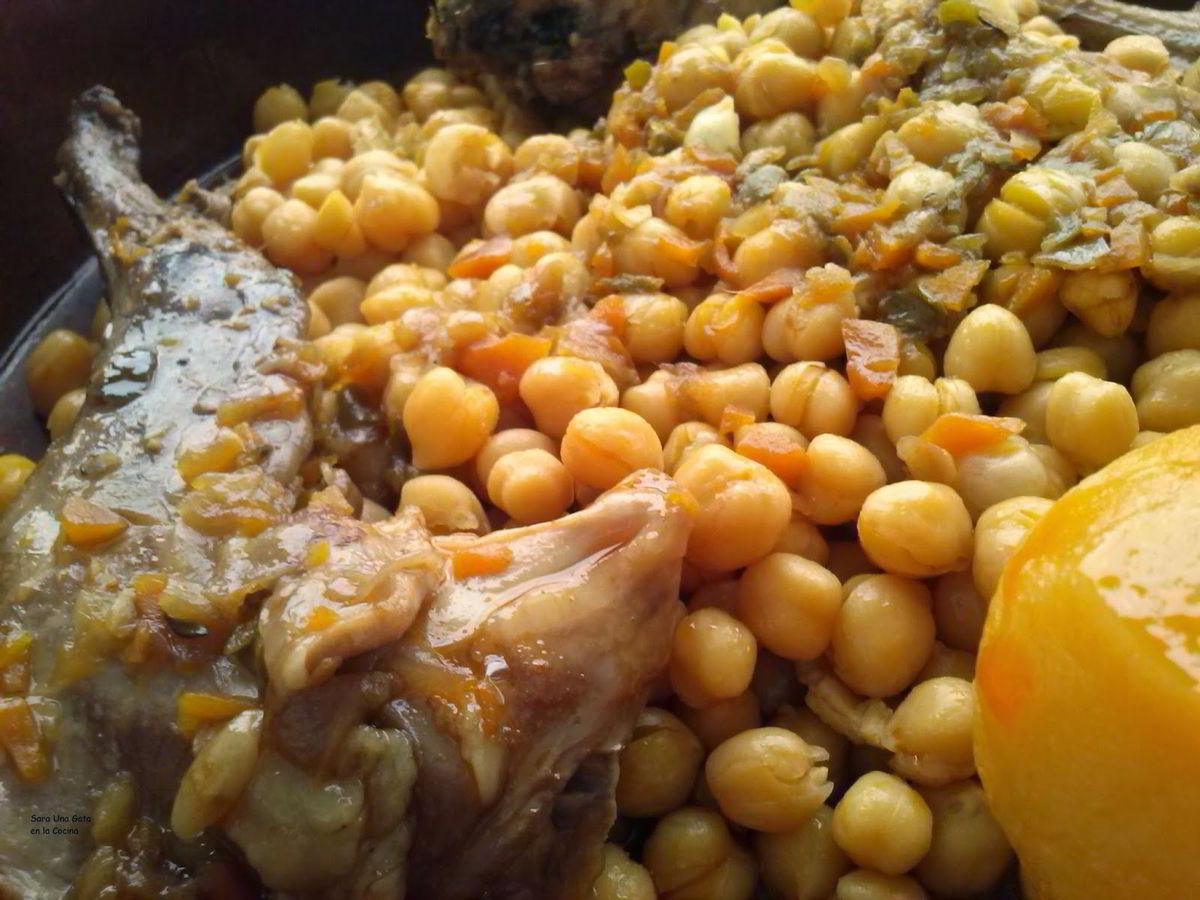 Guiso de garbanzos con un trozo de conejo estofado, zanahoria y patata en caldo ligero